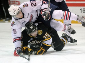 Colin Suellentrop (25) of the Oshawa Generals winds up on top of Sarnia Sting forward Davis Brown Saturday, Feb. 16 at the RBC Centre in Sarnia, Ont. PAUL OWEN/THE OBSERVER/QMI AGENCY