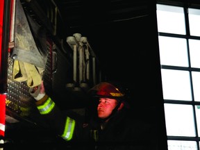 Brockville firefighter Greg Clements is reflected in the door of a fire truck at the city's Laurier Boulevard fire station (RONALD ZAJAC/The Recorder and Times).