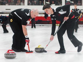 Fanshawe Falcons sweepers Luke Grasby, left, and Cody Heyens make some last-second adjustments to a shot in the OCAA Curling Championships men's gold medal final Sunday at the St. Thomas Curling Club. Fanshawe beat Confederation 7-3 in a blowout. (Nick Lypaczewski, Times-Journal)