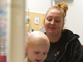 Nicole Clark holds an iPad Friday for her daughter Liliana Bechard who was undergoing chemotherapy at the Children?s Hospital. The donated iPads are used to make life easier for kids in treatment. (MIKE HENSEN, The London Free Press)