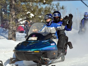 The familiar roar of snowmobiles leaving Cedar Meadows on Sunday morning signaled the take-off for the 39th  Easter Seals Snowrama in Timmins. The event raised more than $15,000 this year.  Co-organizers of the event, Maegan Harvey, front, and her father Bob, wave as they commence their 2013 Snowrama journey.