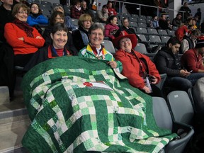 Friends France Isabelle, Sue Amundrud and Margie Byram — from Quebec, Saskatchewan and New Brunswick, respectively — take in the action at the Scotties Tournament of Hearts curling event being held at the K-Rock Centre in Kingston. The quilt, made by Amundrud, will be passed over to the Saskatchewan team should they make the playoffs.(PETER HENDRA The Whig-Standard )