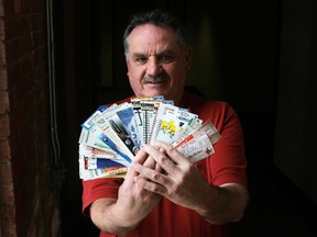Sports fan Guy Din holds a handful of ticket stubs from baseball and football stadiums he has visited across North America. (Elliot Ferguson The Whig-Standard)