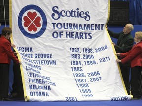 H.E. McDonald, left, Margaret McDonald, Ted Brown and Katherine O’Neill unfurl a banner at the opening ceremonies of the Scotties Tournament of Hearts in Kingston on Saturday. (Danielle VandenBrink The Whig-Standard)