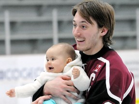 Captain Sean Myers holds seven-month-old Kara Cameron after the Chatham Maroons' 5-4 win over the St. Marys Lincolns on Sunday at Memorial Arena. Players signed autographs, posed for photos and skated with fans after the game. (MARK MALONE/The Daily News)
