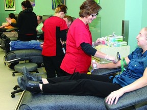 Barb Bakker, a phlebotomist with Canadian Blood Services, helps Helena Greenley make her eleventh donation at the Gardiners Rd. location.          Rob Mooy - Kingston This Week