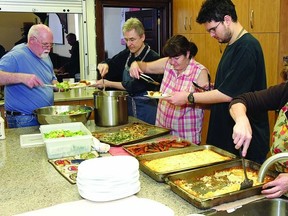 Jen Hurd (right), kitchen coordinator of Lunch By George, fills lunch plates with the help of volunteers (r-l) Mitchel Sutherland, Joan DeGray, Michael Capon and Gordon Blake during one of the weekday lunches that serves between 40-60 people daily at the facility located in the hall of St. George’s Cathedral.        Rob Mooy - Kingston This Week
