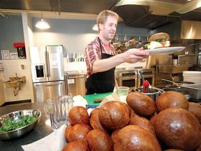 Local chef Ryan O'Donnell serves up a made-to-order brioche breakfast sandwich built from top to bottom with local ingredients from Slow Food Market vendors. (MIKE BEITZ, The Beacon Herald)