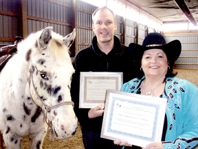 Jason Chickowski, centre, president of Chatham Minor Baseball Association and Terry Jenkins, founder of Acceptional Riders at T.J. Stables, far right, of Chatham, On. display the accessibility awards they received for their contributions to making sports more accessible. (BOB BOUGHNER, The Daily News)