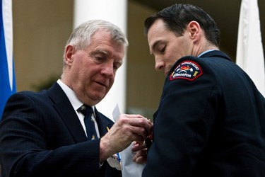 Firefighter Ian McKee (right) receives a Diamond Jubilee Medal from Edmonton Centre MP Laurie Hawn during a ceremony held at Edmonton City Hall in Edmonton, Alta., on Tuesday, February 19, 2013. Twenty-six members were given medals in recognition of outstanding service to the city. Ian Kucerak/Edmonton Sun/QMI Agency