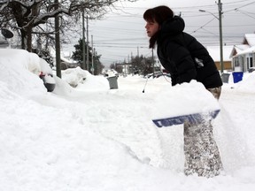 Timmins resident Jennifer Hilder deals with the snow that blocked her driveway Tuesday after the region was hit by another winter storm. Timmins received 25 cm of snow overnight, plus another 15 cm throughout the day.