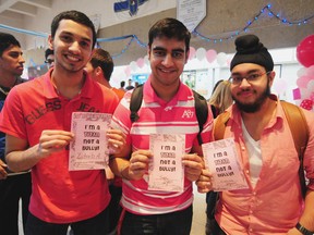 Left to Right: Harry Ainlay High School students Zuhaib Akhtar, Shiv Dass, and Kunwar Singh hold postcards that say ‘I’m a Titan not a Bully’ at the school last week. TREVOR ROBB Edmonton Examiner