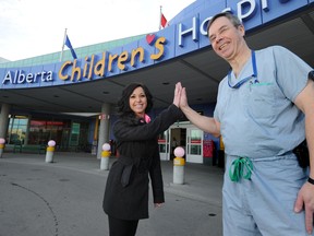 Alyssa Montefresco, a Grade 12 student at George McDougall High School gets a high-five from orthopedic surgeon Dr. Gerry Kiefer (who has performed eight surgeries on Alyssa over the years) outside the Alberta Children’s Hospital. Alyssa’s school has raised more than $130,000 for the Children’s Hospital over the last two years for their oncology unit through a fundraiser event called Ride of the Mustangs, a 48 hour-bike-a-thon. 
STUART DRYDEN/QMI AGENCY