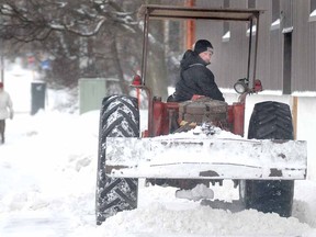Stratford Brewing Company president Joe Tuer clears snow from the front of his downtown Stratford, Ont., business with an early '70s vintage International 454 tractor supplied by his dad Gord, a local longhorn farmer, on Wednesday, Feb. 20, 2013.   (SCOTT WISHART, The Beacon Herald)