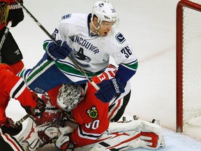 Canucks forward Jannik Hansen (top) crashes into Blackhawks goalie Ray Emery during third period NHL action in Chicago on Tuesday, Feb. 19, 2013. Hansen was given a one-game suspension for his hit on the Blackhawks' Marian Hossa. (Jim Young/Reuters)