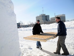 Brothers and snow sculptors Carmen (left) and Aaron Johnson remove the forms that have created large snow blocks over the last two weeks in the field to the south of the Montrose Cultural Centre. The two were preparing for Frost Moon, which begins Thursday. (Adam Jackson/Daily Herald-Tribune)