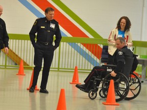 Timmins Police Service officers participated in Wednesday's 24th annual Awareness Day at Northern College. Const. Mike Tambeau showed his wheel chair skills as he rounded a series of cones while going backwards as part of the wheel chair obstacle course. From left are Deputy Chief Des Walsh, Const. Bill Field and Tambeau.
