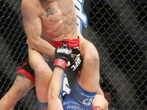 Bryan Caraway (blue trunks)  fights Mitch Gagnon (black trunks) during UFC 149 July 21, 2012 in Calgary, AB. JIM WELLS/CALGARY SUN/QMI AGENCY.