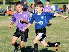 Deni Goure, left, and Alex Muharrem chase the ball during a Chatham Youth Soccer Association under-9 game in July 2012. (MARK MALONE/The Daily News)