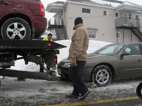 A driver watches as a tow-truck operator hitches up his motor vehicle after a two-car collision at the intersection of Second and St. Felix streets, Thursday morning in Cornwall.