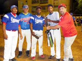 Kiko Acevedo, right, an Ancaster resident, presents his countrymen with bats to allow kids in his home country of Dominican Republic to play baseball. More than a dozen other players, including one from Paris, helped him donate the equipment in late January 2013. Read the story on page 2. SUBMITTED PHOTO