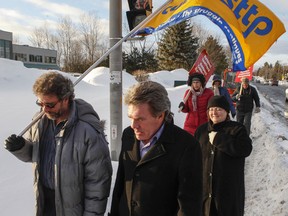 Sean McKenny, president of the Ottawa and District Labour Council, right, walks with teachers, education professionals, school support workers and other citizens protest Bill 115 outside MPP Phil McNeely's office in Blackburn Hamlet Thursday, Feb. 21, 2013.  (Darren Brown/Ottawa Sun/QMI Agency)