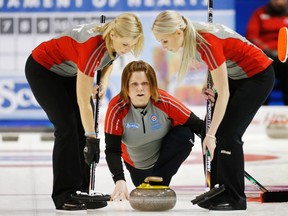 Northwest Territories/Yukon skip Kerry Galusha throws a rock while teammates Wendy Miller, left, and Megan Cormier wait to sweep during a game against Nova Scotia at the Scotties Tournament of Hearts curling championship at the K-Rock Centre on Tuesday. (Mark Blinch/Reuters)