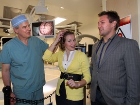 Dr. Keith Aronyk checks his work on Kristin Henry as her husband Jon looks on.  Dr. Aronyk performed brain surgury on Henry last month. The UofA Hospital unveils their new Dan And Bunny Widney Intra-operative Magnetic Resonance  Imaging Surgical Suite in Edmonton, AB., on Feb 21, 2013.  Perry Mah/Edmonton Sun/ QMI Agency