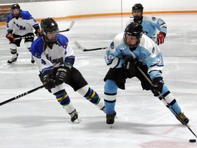 St. Mary's centre Kyle Crossman tries to slip around St. Joe's defenceman Taylor Emmerton in the third period of their first round robin playoff game Thursday afternoon at Timken Arena. St. Joe's defeated the Warriors 3-0 giving St. Mary's a must-win game against Holy Cross Monday to move onto the finals. GREG COLGAN/QMI Agency/Sentinel-Review