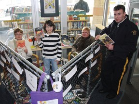 Michelle Toombs, left, Alejandro Torres, Kathie Gaudes and Const. Christopher Russell, right, prepare for Freedom to Read Week at the library, which starts Feb. 24. Participants will be placed in the Cage of Oppression, reading banned or challenged books until they make bail.
TESSA CLAYTON/AIRDRIE ECHO