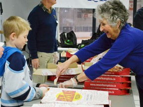 After participants were done their activities for the 11th annual Rotary Winterama, pizza and refreshments were served in the Rotary Hall at The Plex on Saturday (Feb. 16, 2013). Pictured is rotarian Arlene Letheren serving a fresh slice of New Orleans pizza to participant Cooper McCulloch.