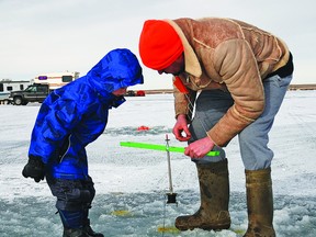 Craig Hopf, a resident from Brooks, shows his son Jesse, 6, how to set a lure in an ice fishing hole on Friday at Badger Lake, where the annual ice fishing derby was held. Craig also brought his daughter Karli, 4. He has taken part in the derby with a group of friends every year for about 10 years, in exception to last year, when the event was cancelled due to unseasonably warm weather that created dangerous conditions on the ice. Although it hasn’t been the most frigid February this year, conditions were favourable enough to hold the derby.