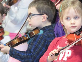 Cayley School Grade 1 students show their perfect postures for playing violins during the school's Valentine's Day tea Feb. 14, 2013.