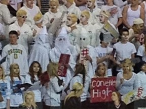 Three students in North Dakota were photographed wearing what appeared to be Ku Klux Klan outfits during a high school hockey game. (Twitter photo)