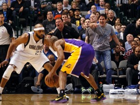 Dallas Mavericks owner Mark Cuban (R) reacts as guard Vince Carter (L) guards Los Angeles Lakers guard Kobe Bryant during the second half of their NBA basketball game in Dallas, Texas February 24, 2013. (REUTERS)