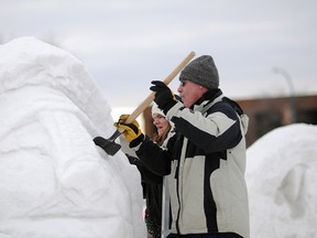 Keith Prestone and Debbie Berlasty carve a block of snow into a lion at the first ever Frost Moon Festival near the Montrose Cultural Centre on Saturday. The event featured sledding, skating, snow sculptures, bonfires, musical performances and more. (Aaron Hinks/Daily Herald-Tribune)