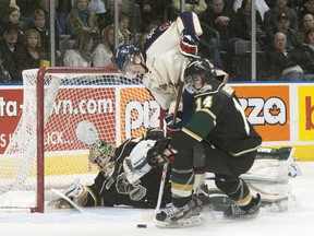 Knights defenceman Tommy Hughes ties up Saginaw Spirit forward Jimmy Lodge beside fallen London goalie Anthony Stolarz during their OHL game at Budweiser Gardens on Sunday. The Knights won 3-2. (CRAIG GLOVER, The London Free Press)