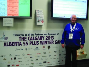 Athlete and competitor in the Calgary 2013 Albetrt Plus 55 Winter Games Bob Walker stands in pride before the poster advertising the events of Feb. 13-16.