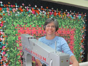 Terry Anderson, president of the Norfolk County Quilter’s Guild, has her own quilting machine in the basement of her home in Vittoria. The Ontario Association of Agricultural Societies recently voted Anderson’s quilt in the background – titled Tropical Blooms – as the Provincial Grand Champion for 2012. (MONTE SONNENBERG Simcoe Reformer)