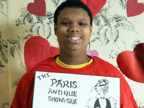 Chaldon Lewis, a student in the Self-contained Multi-exceptional Class at Paris District High School, shows off one of the many posters he voluntarily distributed to help publicize the 40th Paris Antique Show and Sale on March 2 and 3 at the Paris Fairgrounds. PHOTO BY AMANDA TAYLOR