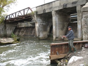 File photo 
Ollie Stegerman of Garnet fishes for trout on the down side of the Misner Dam in Port Dover in this file photo. A repair job to the dam that met provincial specifications could cost as much as $10 million.