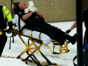 An Alberta Sheriff screams in pain as he is taken to a waiting ambulance after being shot in the Whitecourt courthouse. Two prisoners are now in custody after fleeing the scene. (Courtesy of Lynden McBeth/XM 105 FM)