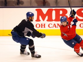 Maple Leafs defenceman Mark Fraser (left) keeps an eye on forward Clarke MacArthur during a rare practice at the Air Canada Centre yesterday. Fraser said he is thrilled to be able to contribute to the team the way he has so far this season. (MICHAEL PEAKE/Toronto Sun)
