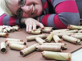 Lori Greer, operations manager at the Agape Centre in Cornwall, is surrounded by only a few of the 122,000 pennies that were donated by the community from November 2012 to early February 2013. The pennies will help purchase healthy snacks for children. 
Staff photo/ERIKA GLASBERG