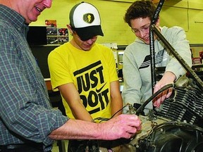 Marc Claege, a transportation technology teacher at LaSalle Secondary School, and students Braden Elliott and Brandon Hallett work on a Formula One SAE race car the class is restoring.      Rob Mooy - Kingston This Week