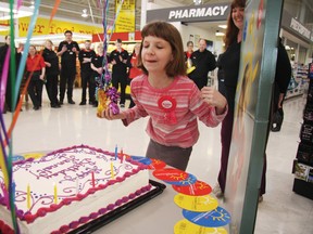 Hannah Hughes, 10,  blows out the candles on her birthday cake at the nofrills supermarket in Airdrie on Thursday. The store donated $2, 335 to Hughes’ Irricana family.
TESSA CLAYTON/AIRDRIE ECHO