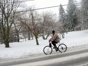 A man rides a bike in Trenton on Wednesday after snow fell across the Quinte area.