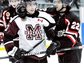 Chatham Maroons' Thomas Eady is grabbed by Lambton Shores Predators' Ferdinando Colella (22) on Oct. 14 at Memorial Arena. The teams face off again Thursday in Game 1 of their GOJHL playoff series in Chatham. MARK MALONE mark.malone@sunmedia.ca