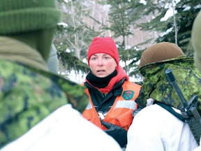 One of the Canadian Rangers talking to some of the reservists about building a shelter.
