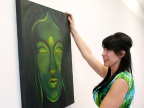 Tammy Baduk tries to find the perfect spot to hang her painting, Spectrum, as she prepares her exhibit Zen. The artwork, inspired by Buddhism, will be featured at the Centre for Creative Arts during the month of March. (Kirsten Goruk/Daily Herald-Tribune)